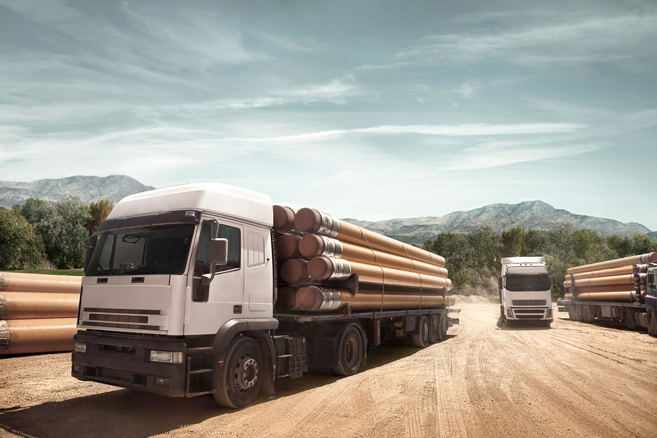 trucks delivering giant pencils by Emre Gologlu