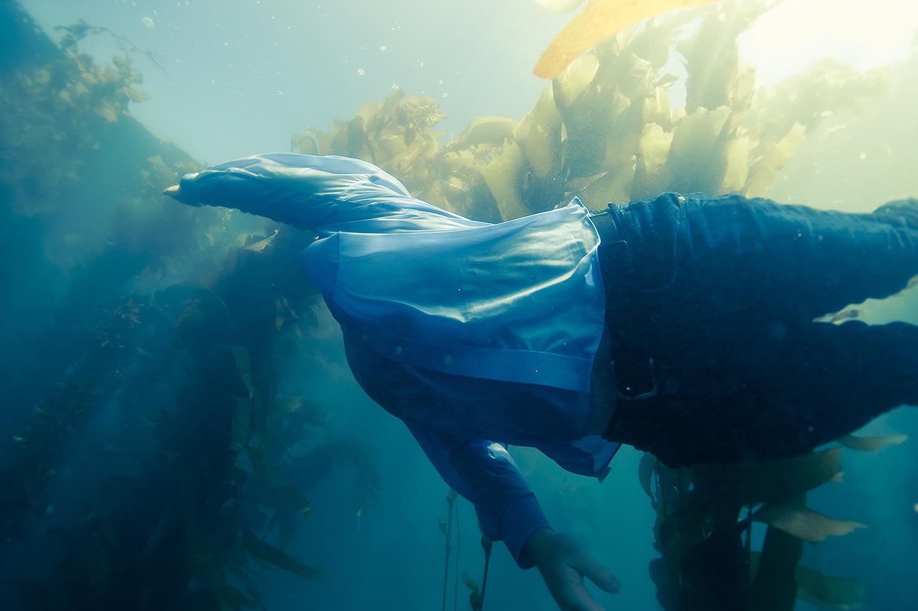 man swimming in blue and green water, photography by John Trevino