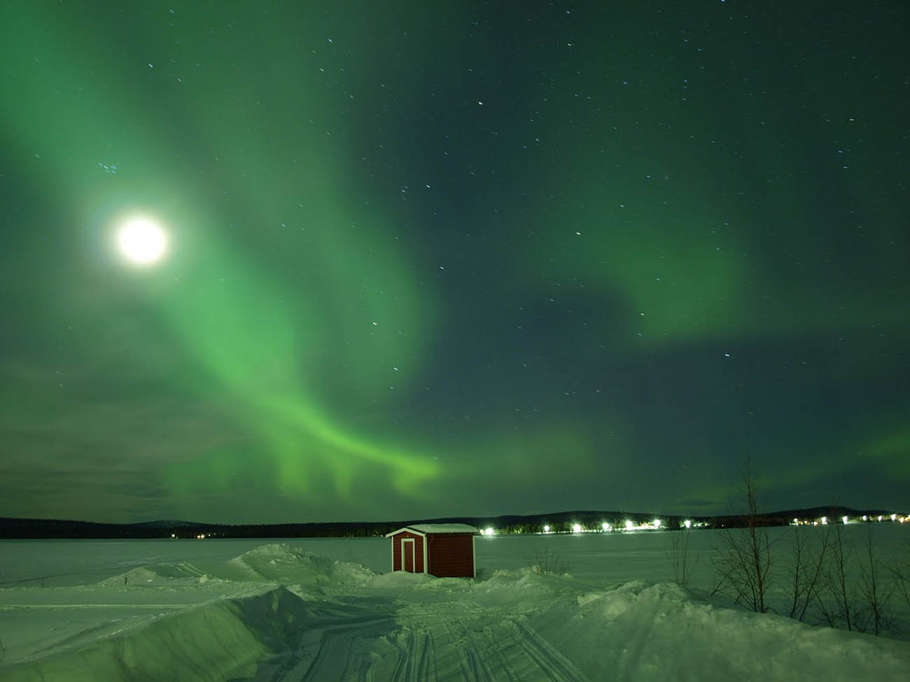 green northern lights snow