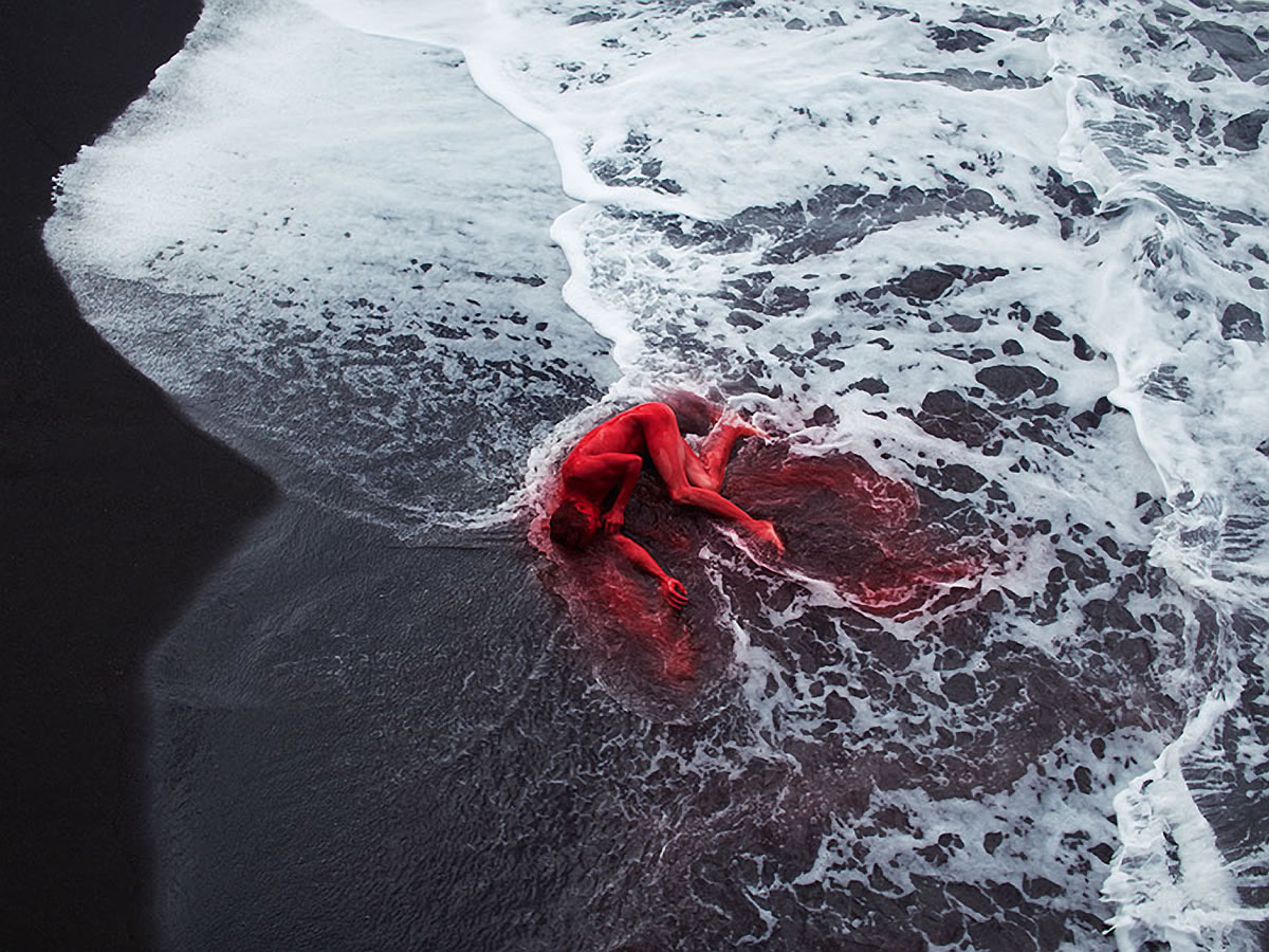 red dust on man lying near waves by by bertil nilsson