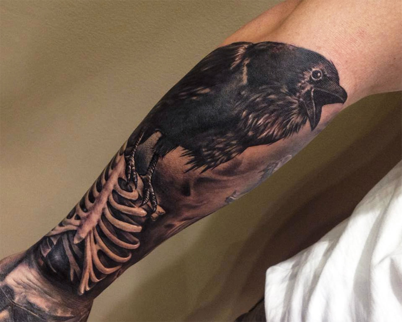 crow and skeleton tattoo on arm by Benjamin Laukis