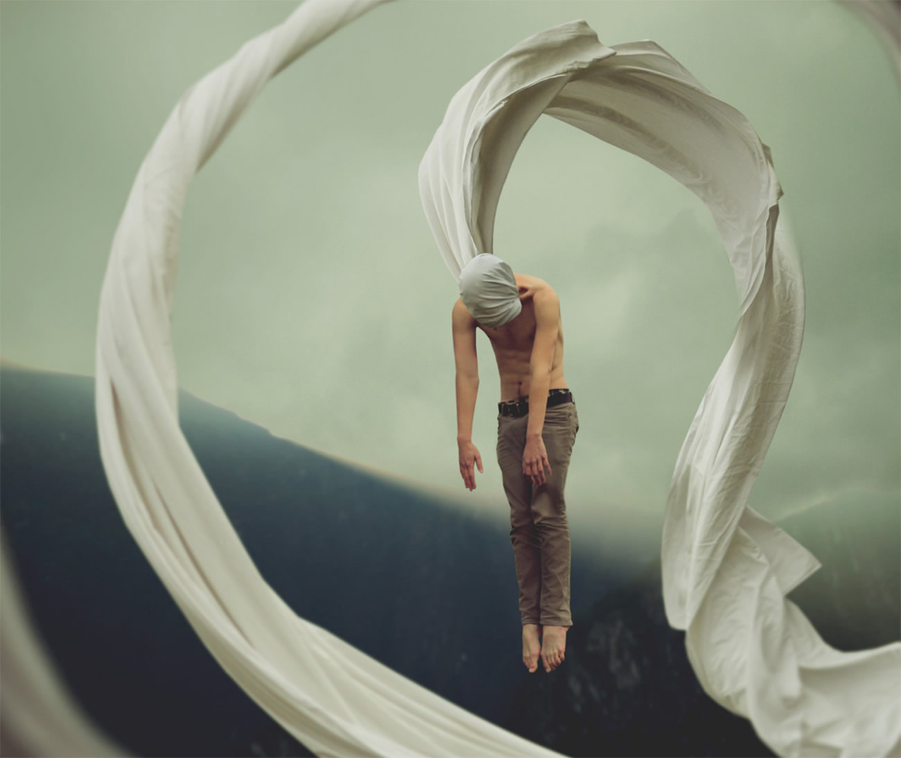 man flying in air from a wrapped sheet on head, photography by kyle thompson