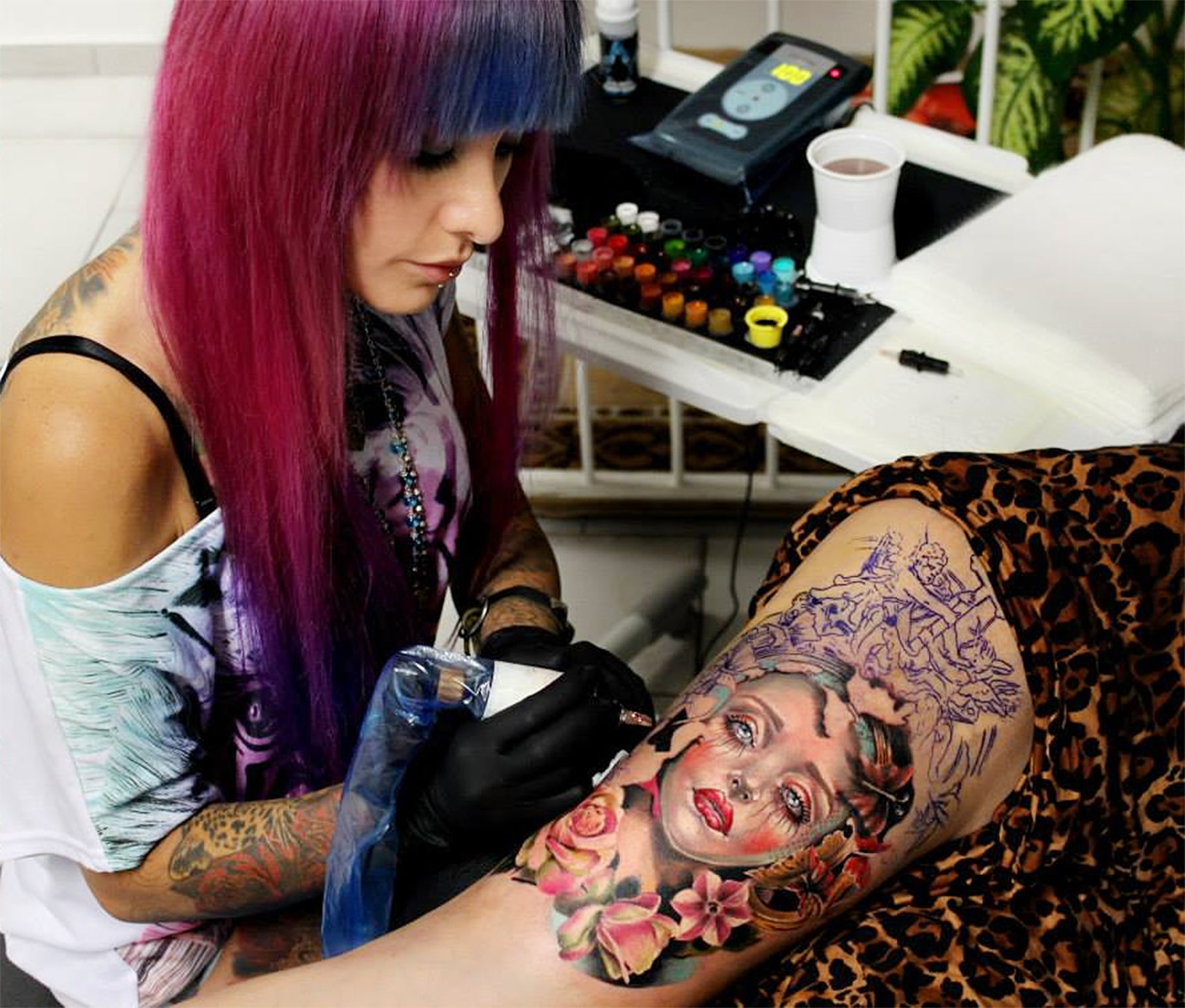Moni Marino tattooing a client's leg