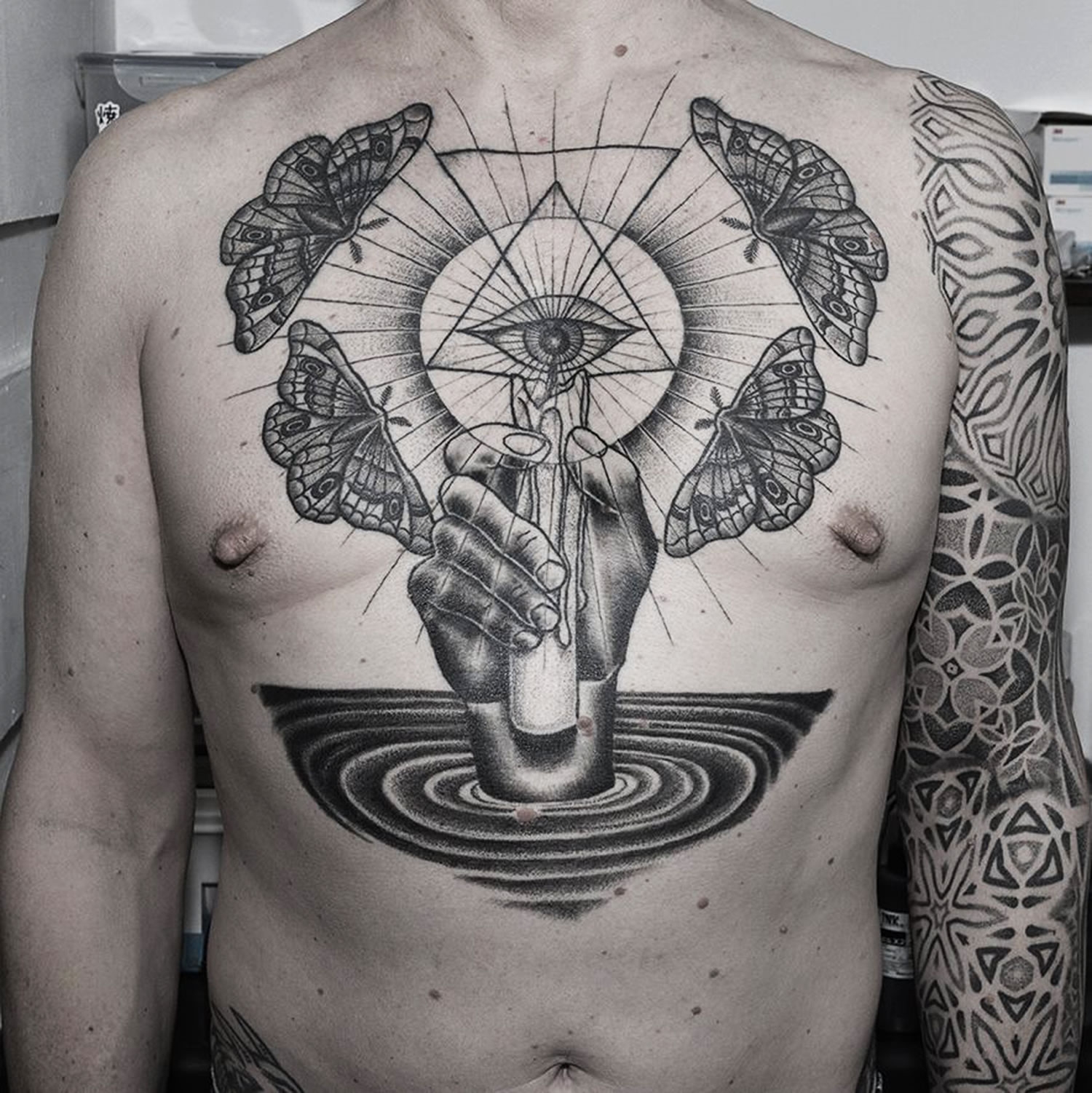 hand with candle and eye of providence, tattoo on chest by jonny breeze