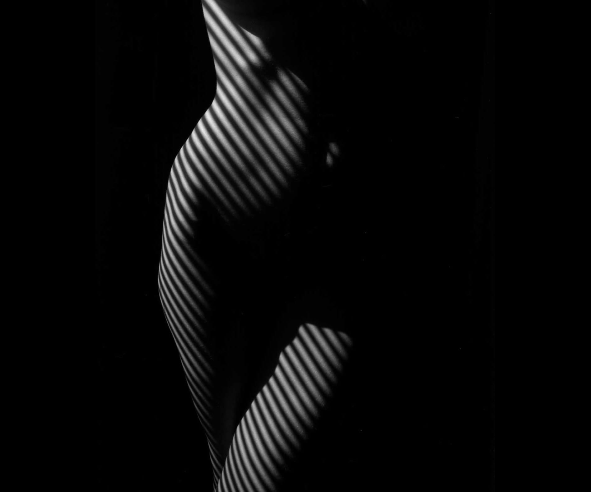 woman with crossed legs, standing up, zebra striped nude, photography by lucien clergue