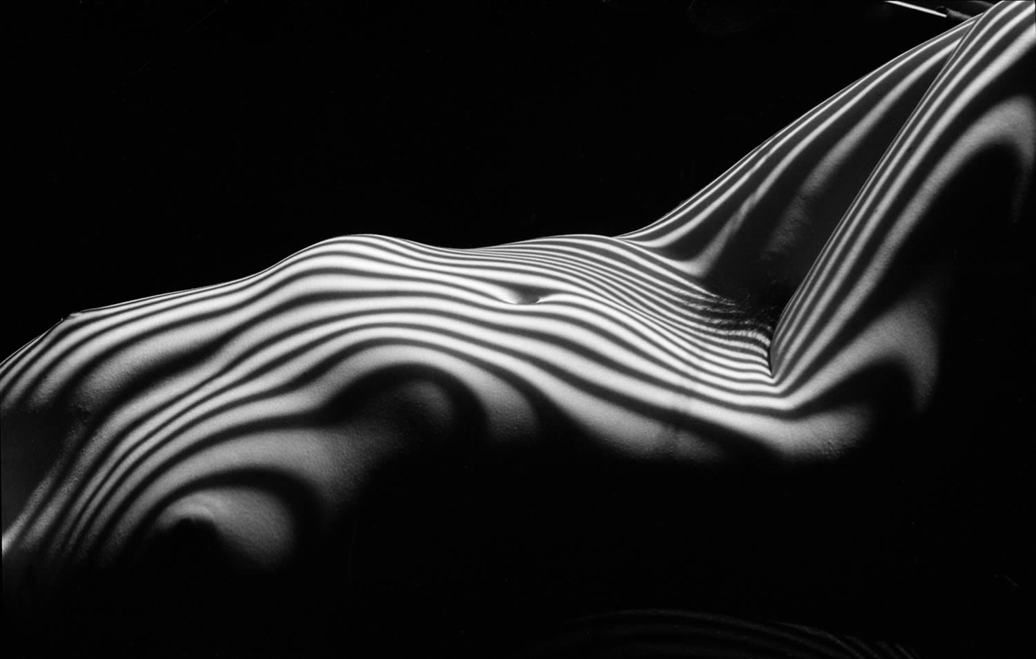 body lying down, zebra striped nude, photography by lucien clergue