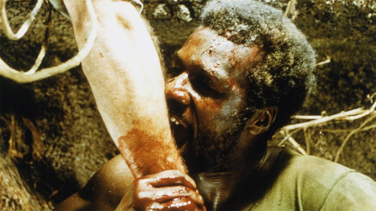 man eating human leg in Cannibal Apocalypse