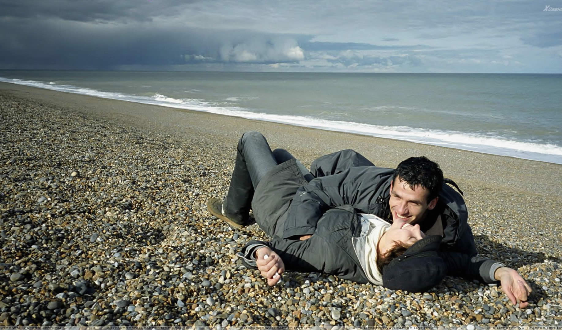 couple on the beach, lying down and hugging in 9 songs