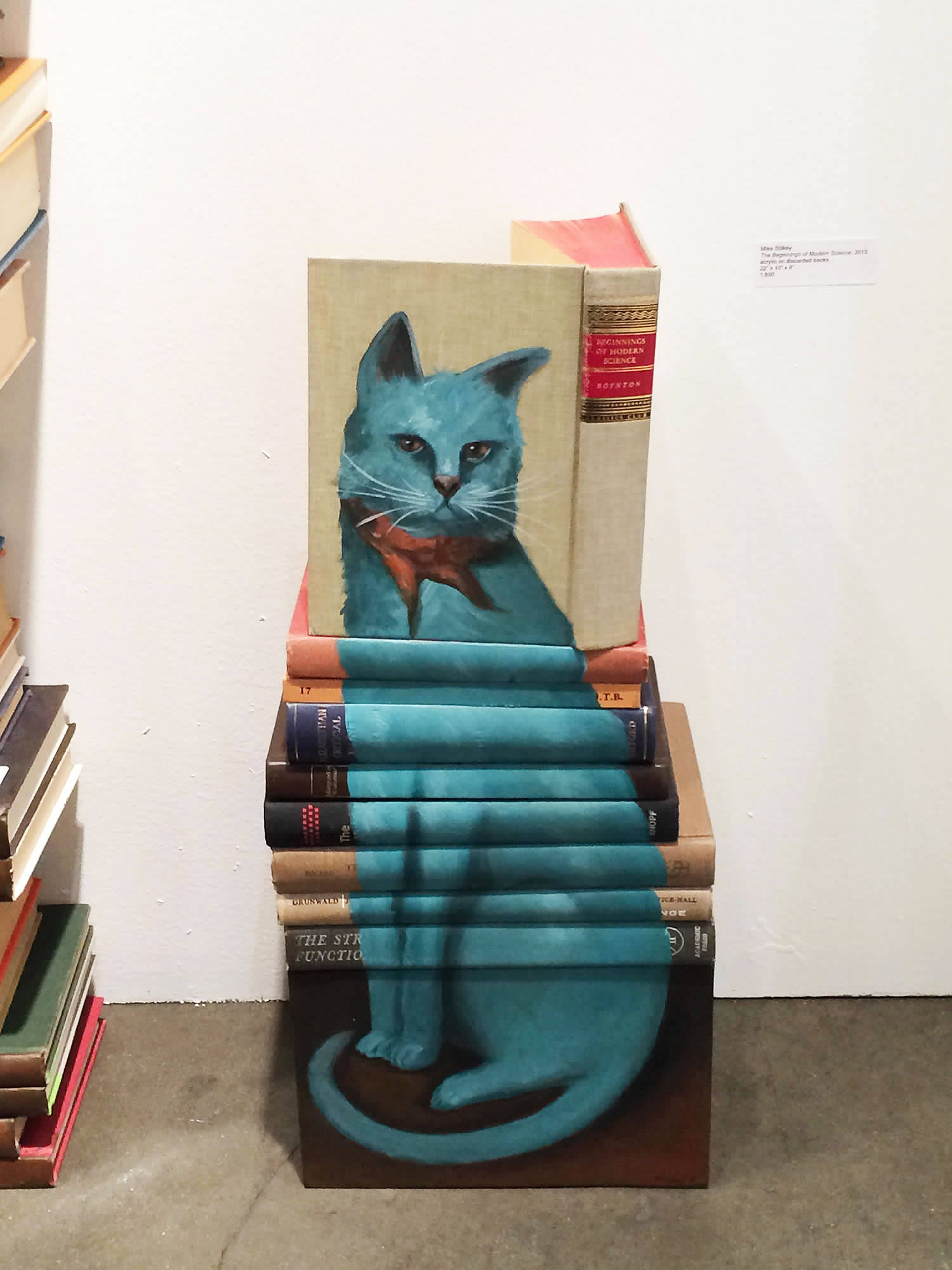 blue cat painted on book covers by mike stilkey