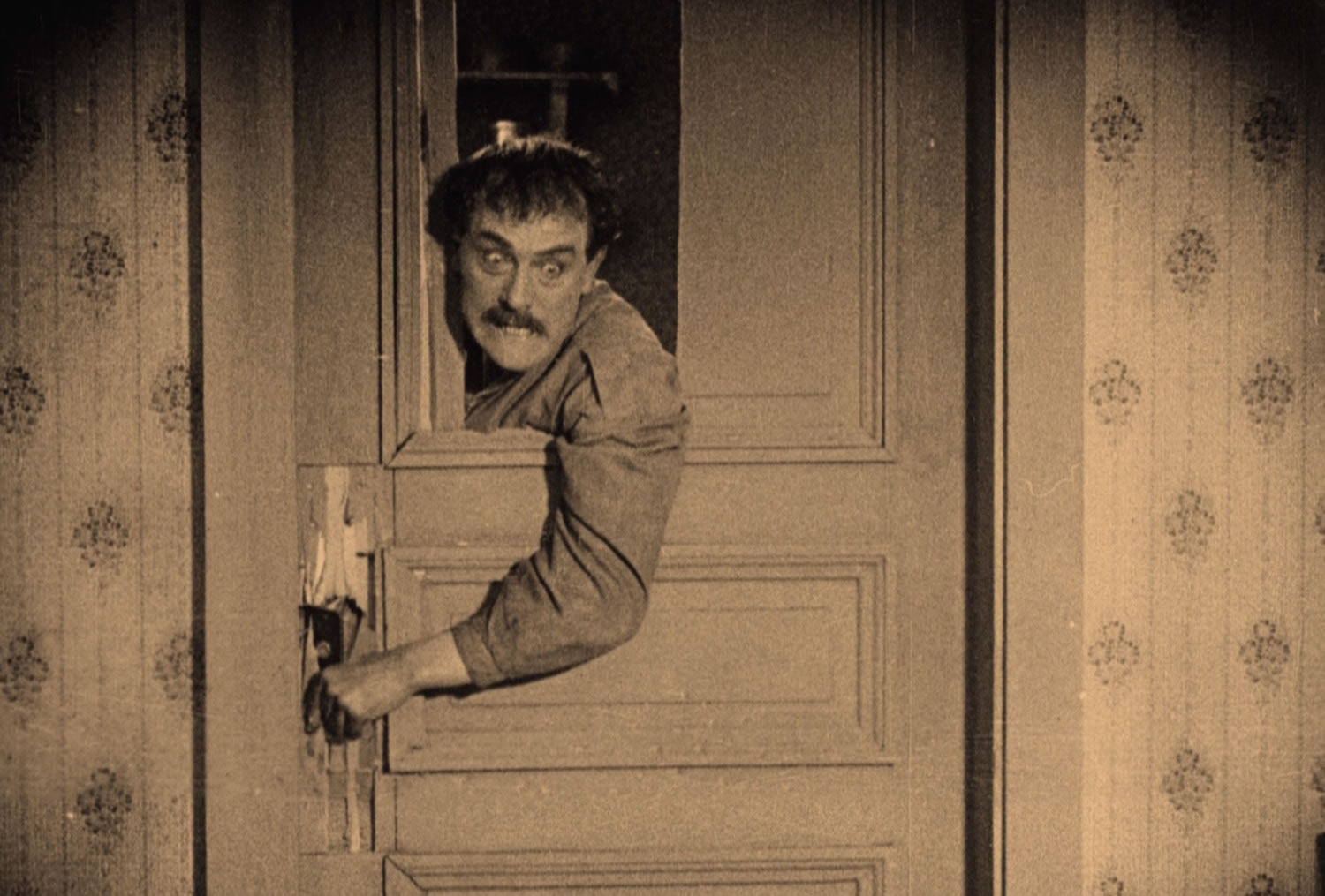 David Holm (Victor Sjostrom) hacks at a wooden door in "The Phantom Carriage" (1921)