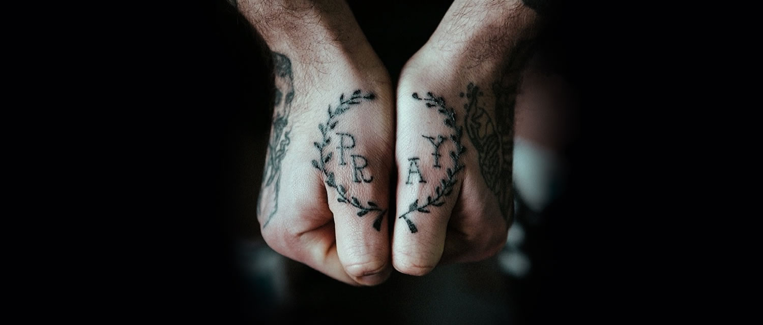 words pray tattooed on two hands