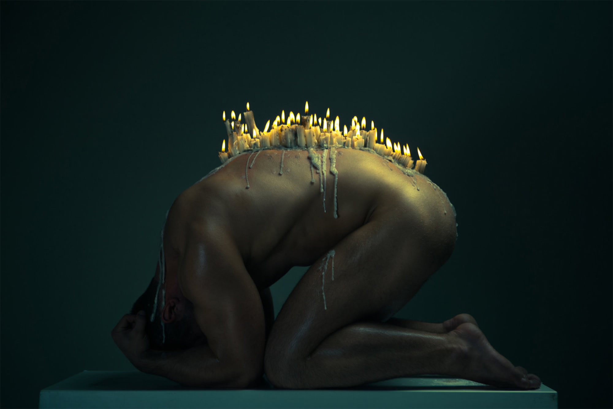 candles melting on man's back, nude photo by ekaterina zakharova