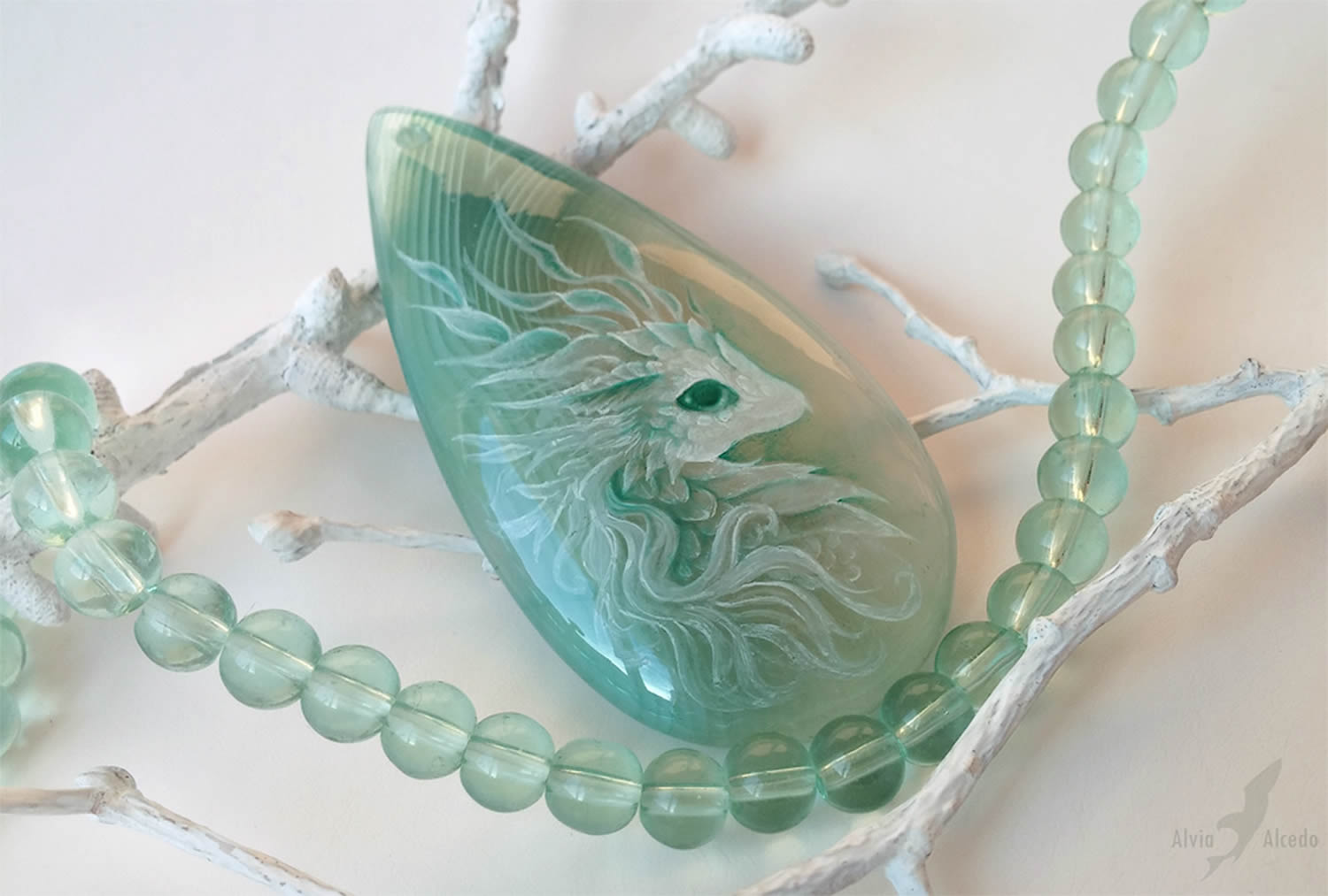 mint green stone with white fantasy creature