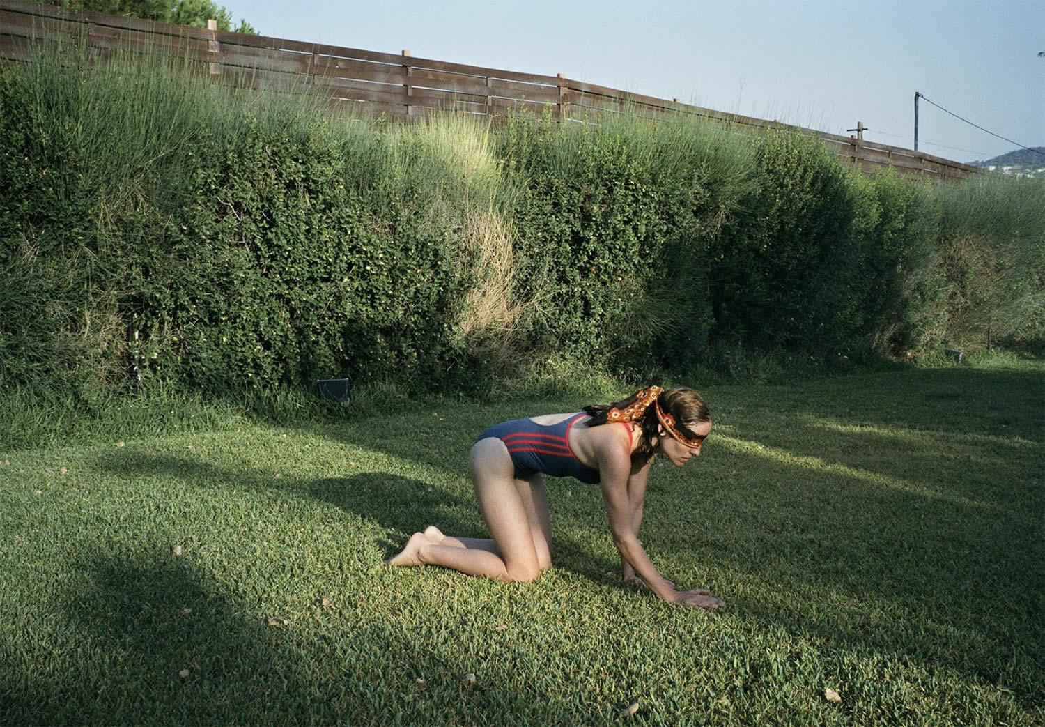 woman blindfolded crawling on grass in dogtooth movie