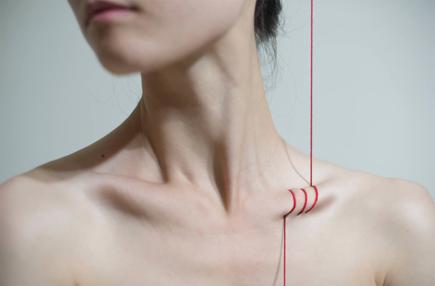 red thread through rib cage, photo by yung cheng lin