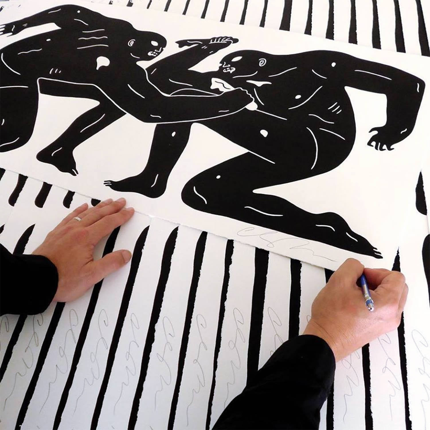 the artist signing a print, cleon peterson