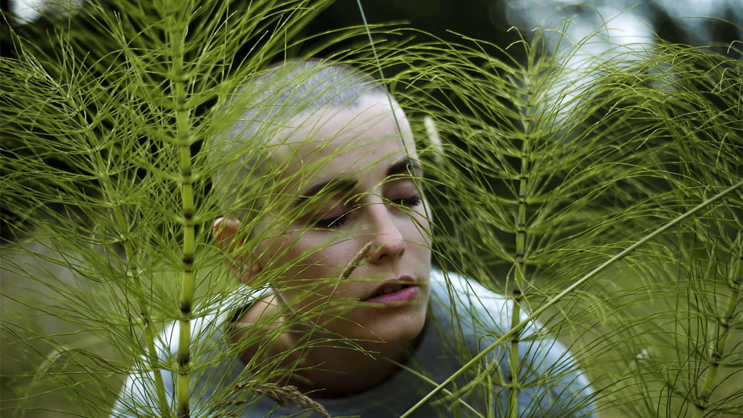bald headed girl ,and green leaves