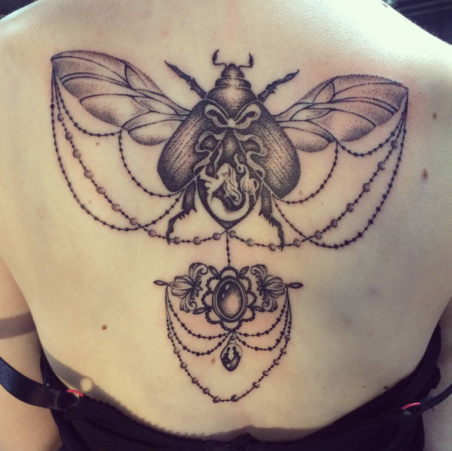 insect and victorian jewelry tattoo on back