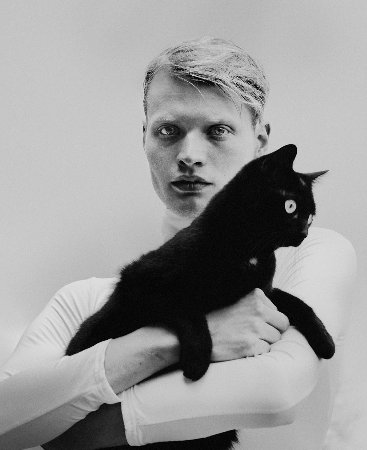 blonde model holding black cat