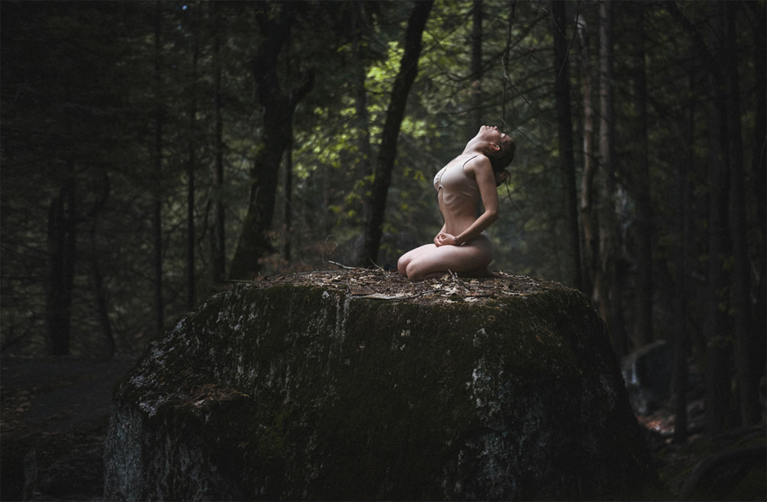 self-portrait artist sitting on forest ground, in nature