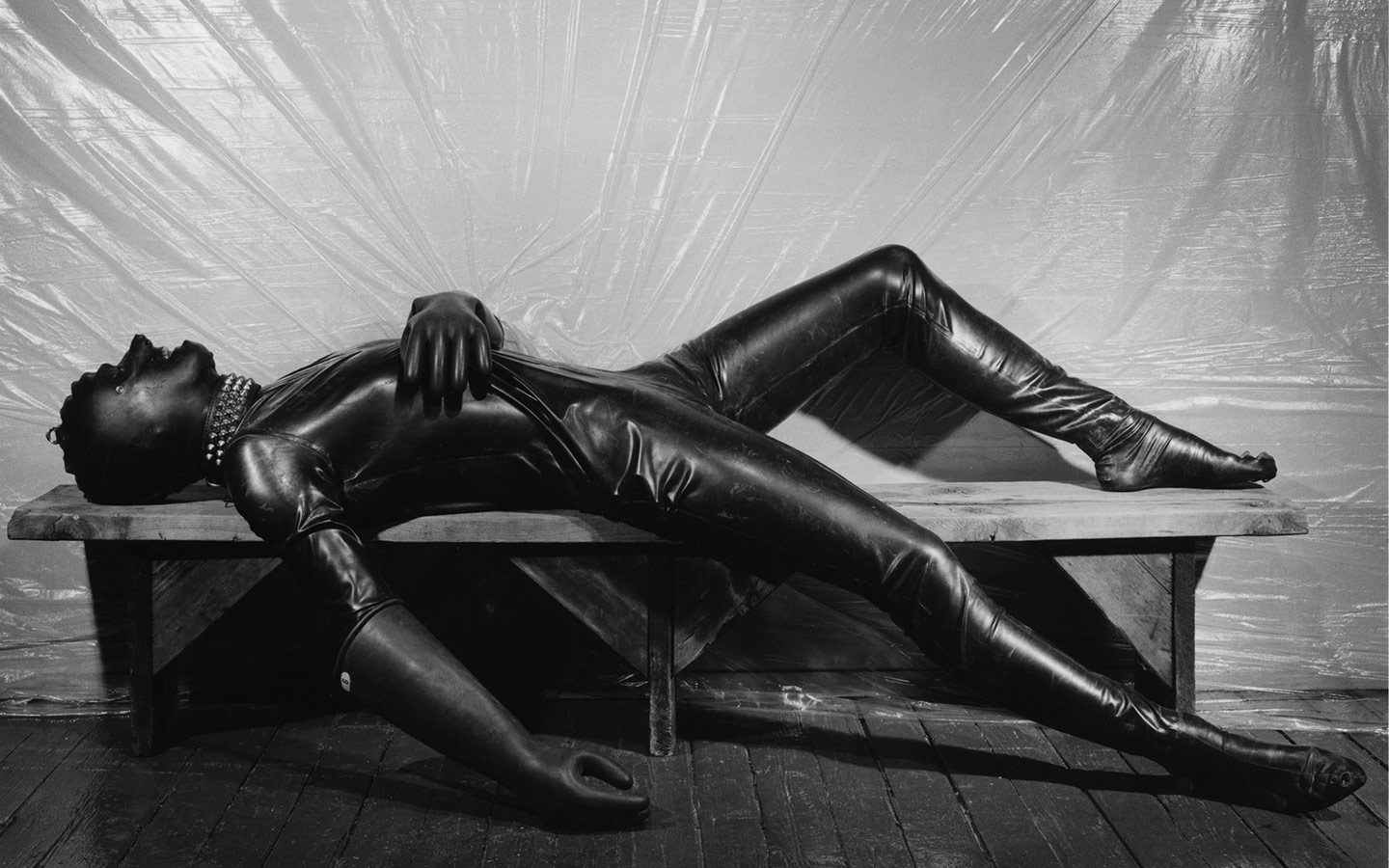 Robert Mapplethorpe - man lying down in S&M full body suit