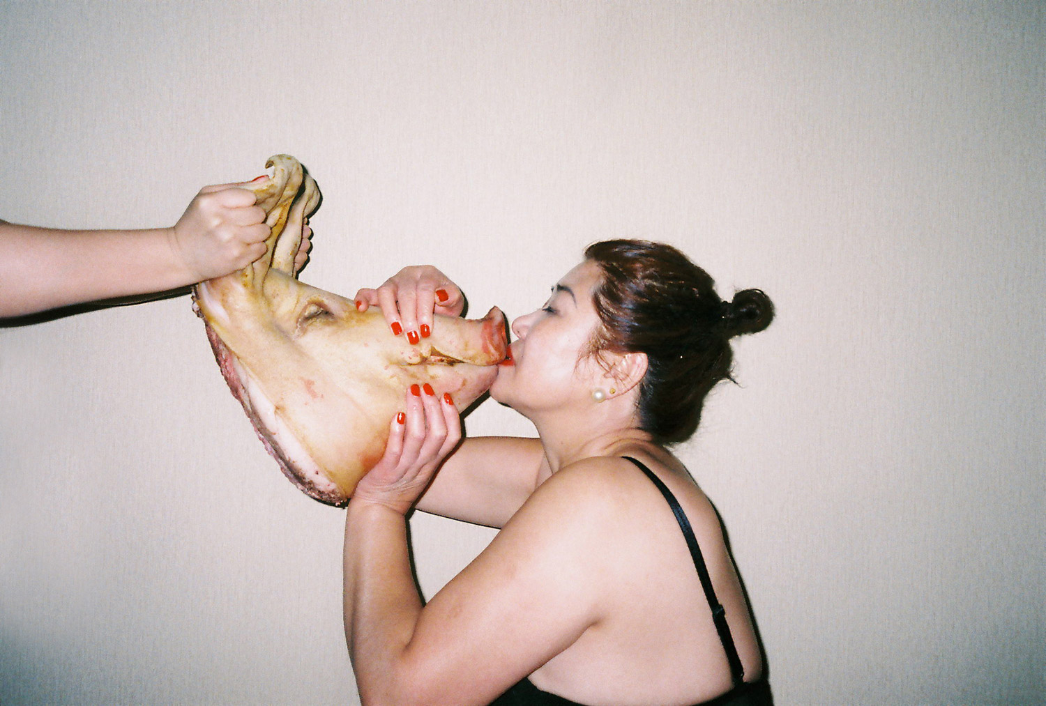 Ren Hang - candid photo of woman kissing severed pig head