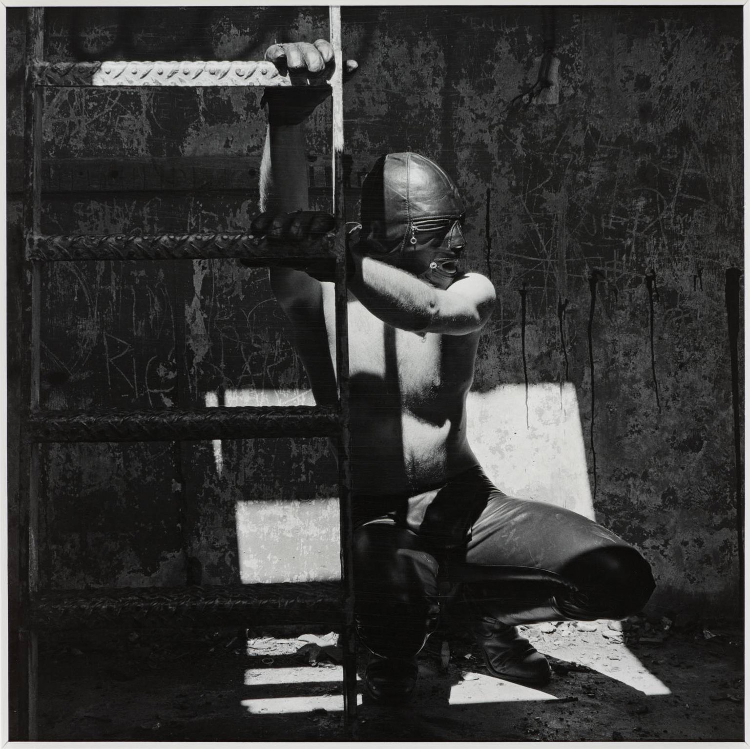 Robert Mapplethorpe - man climbing on ladder wearing S&M gear