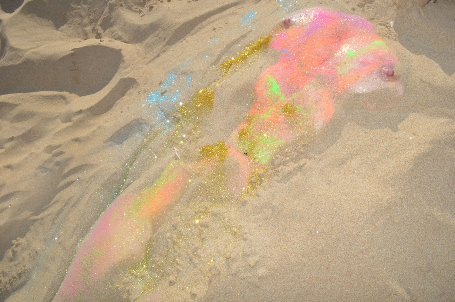 shiny nude body in beach sand