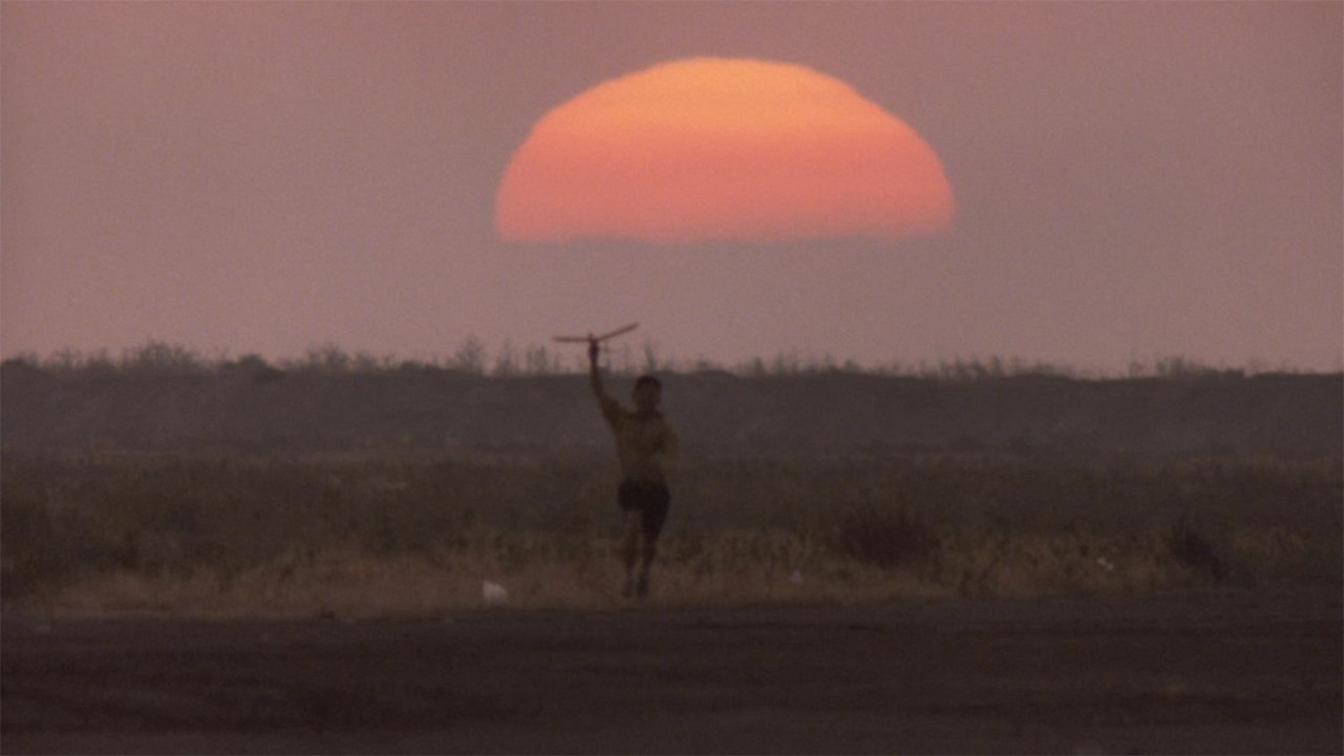 empire of the sun, boy playing, flying a plane in hand