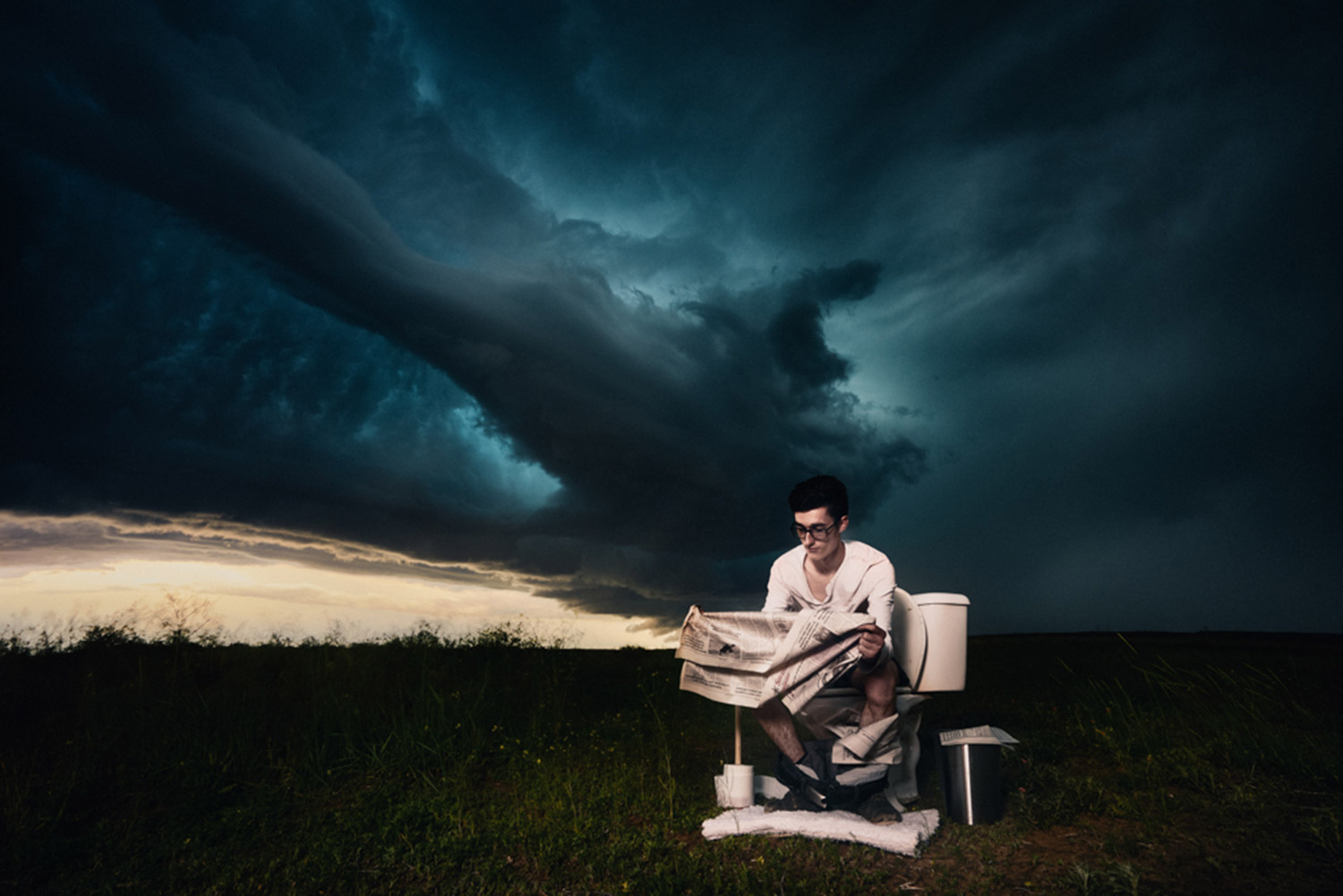 Benjamin Von Wong - man on toilet in field under storm