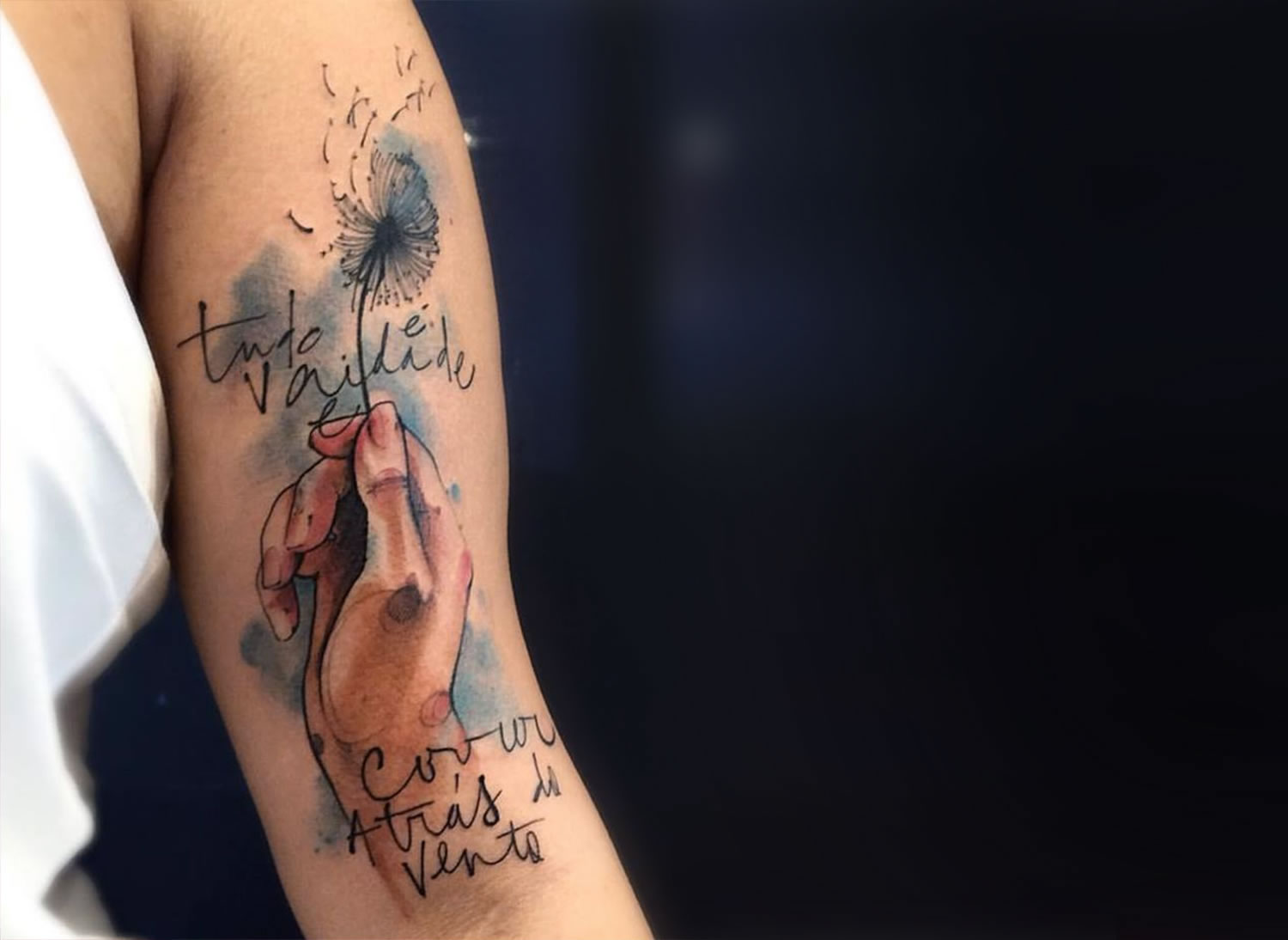 tudo é vaidade e corre atras do vento. collaborative tattoo by Victor Montaghini and fabio maca. hand holding a dandelion