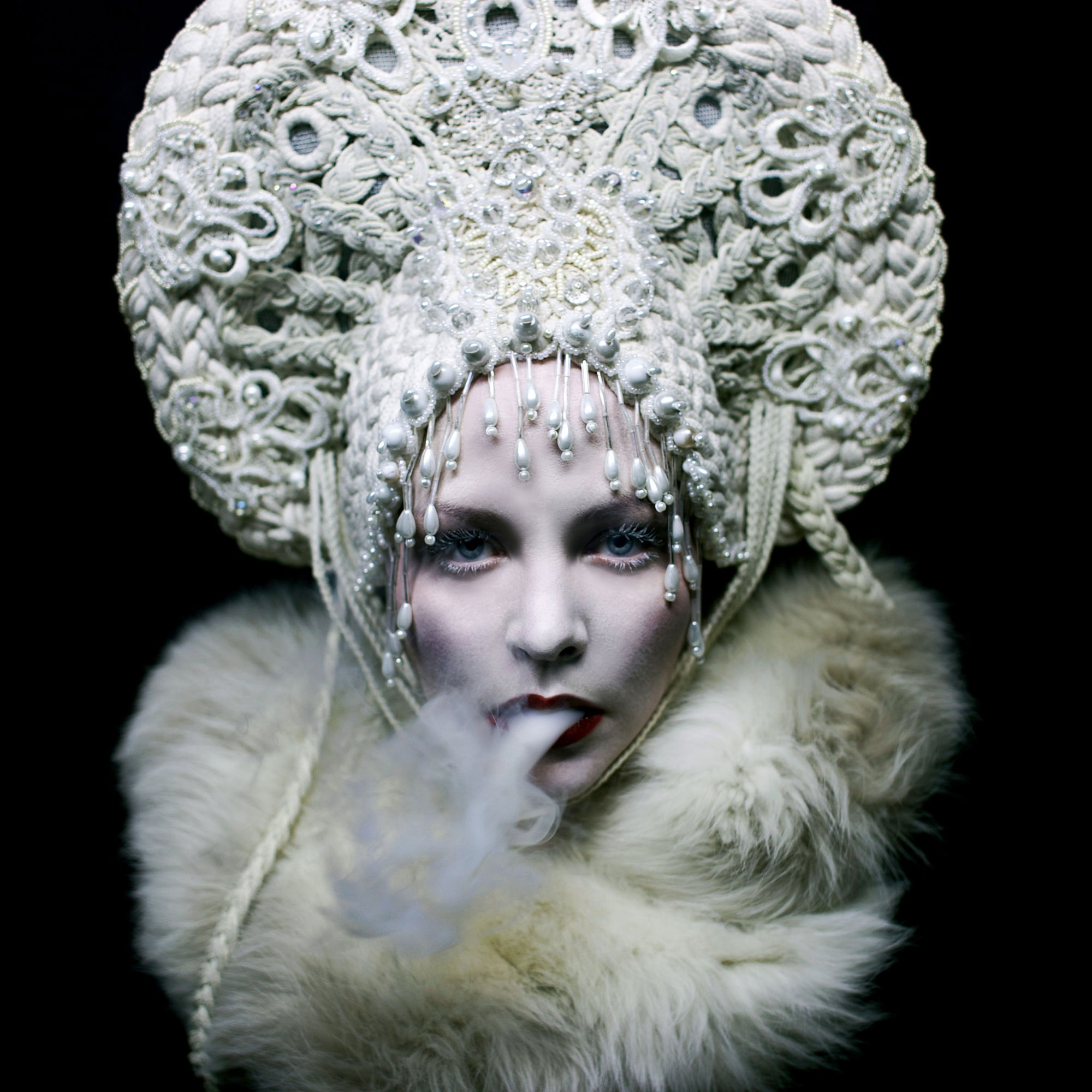 Helen Warner, White Mischief - woman blowing smoking wearing white fur and crown