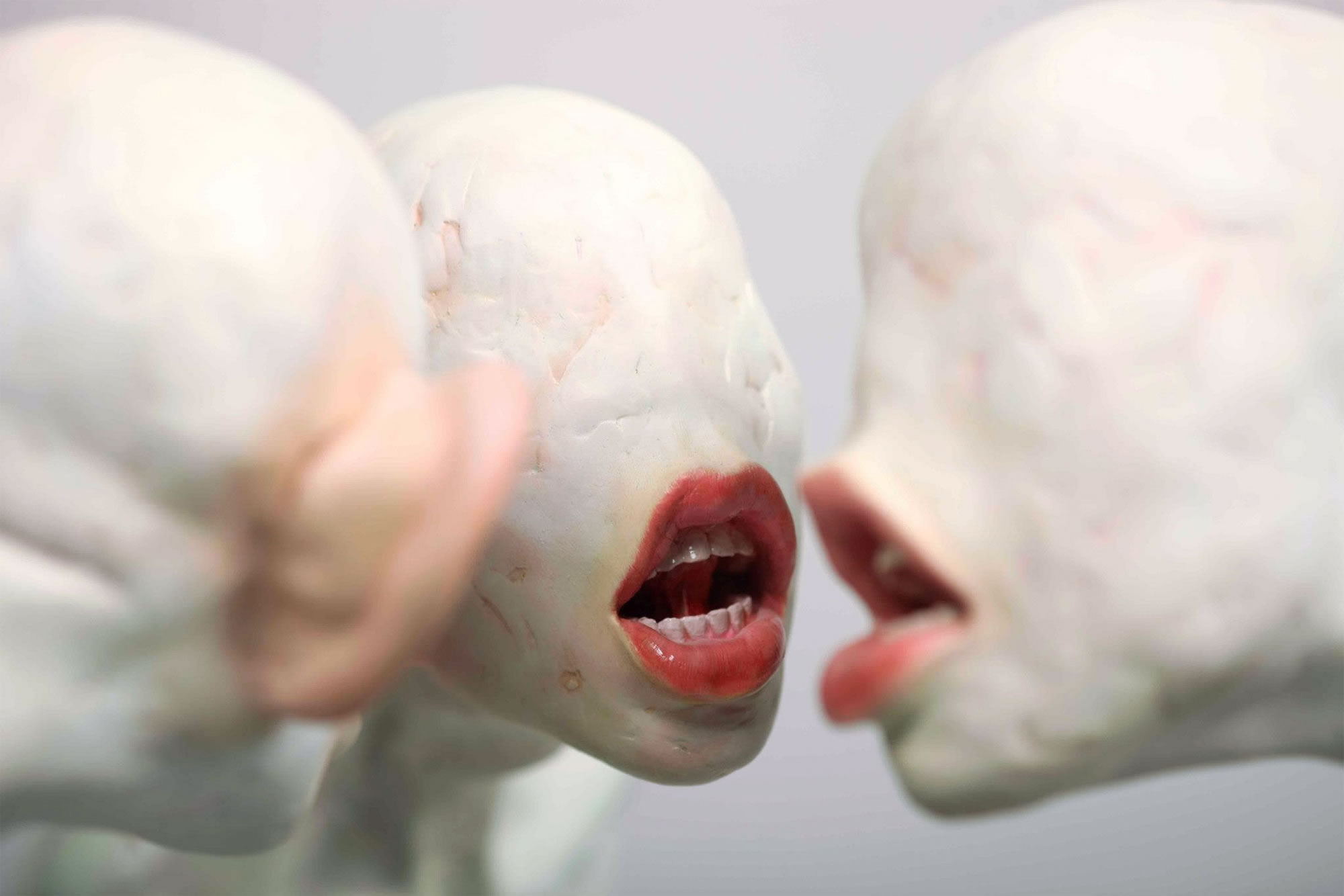 strange sculptures by Xooang Choi, faces with a mouth no eyes or nose