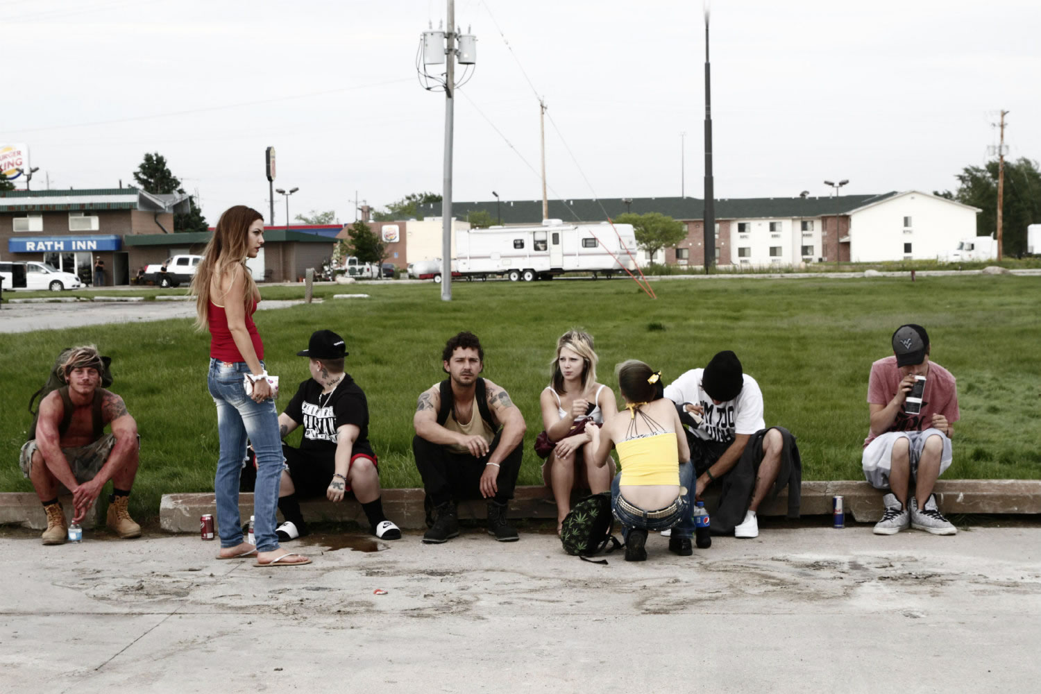 young audience sitting on sidewalk, in american honey movie