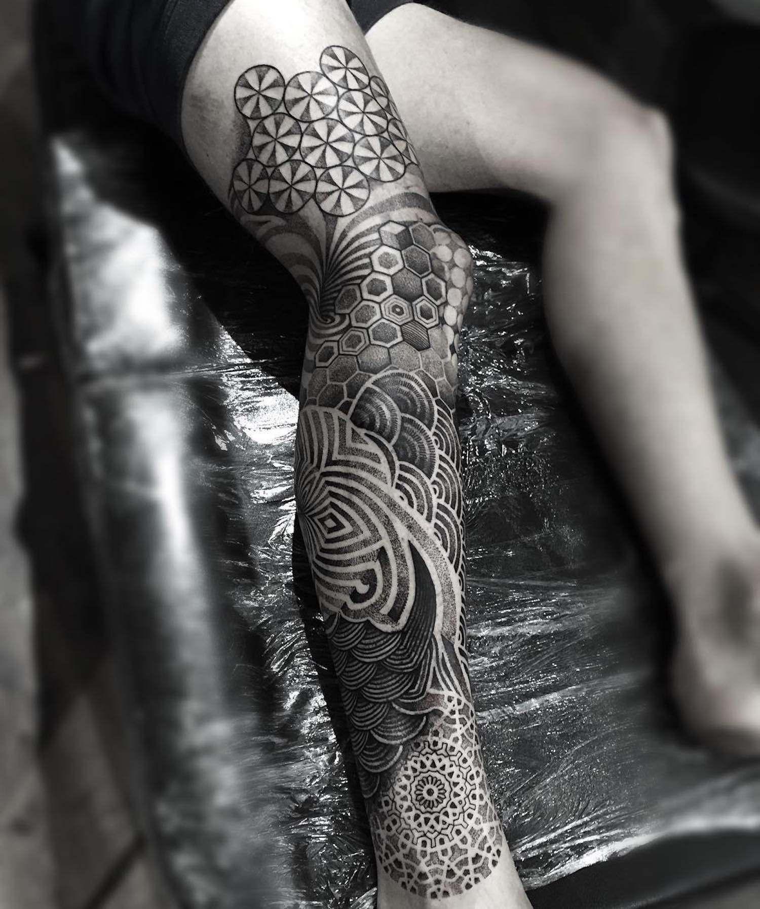 swirling geometric tattoo down leg by paul davies 