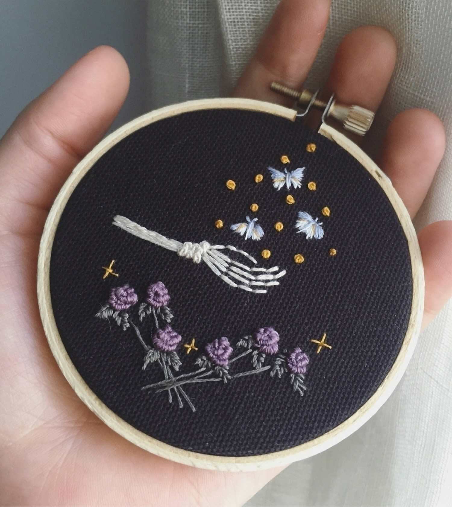 skeleton hand, butterflies and purple flowers (embroidery) on black cloth