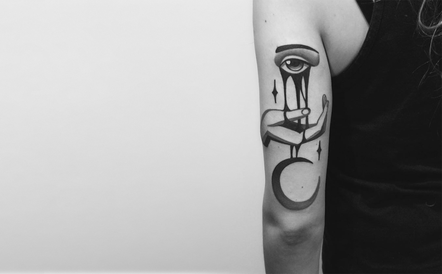 eye melting on hand, tattoo on arm