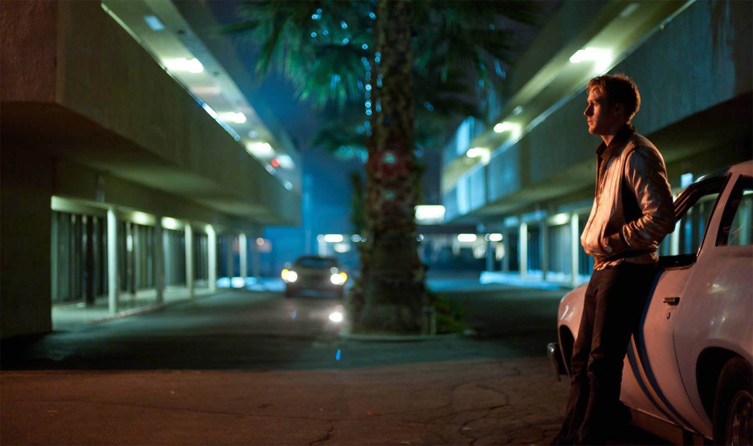 ryan gosling in drive, leaning on a car