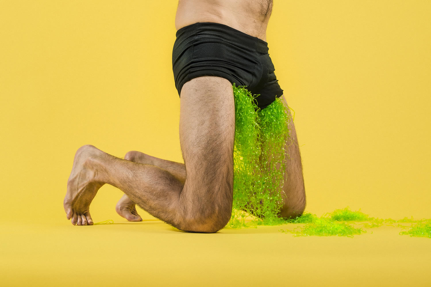 green liquid flowing out of men's shorts, photography