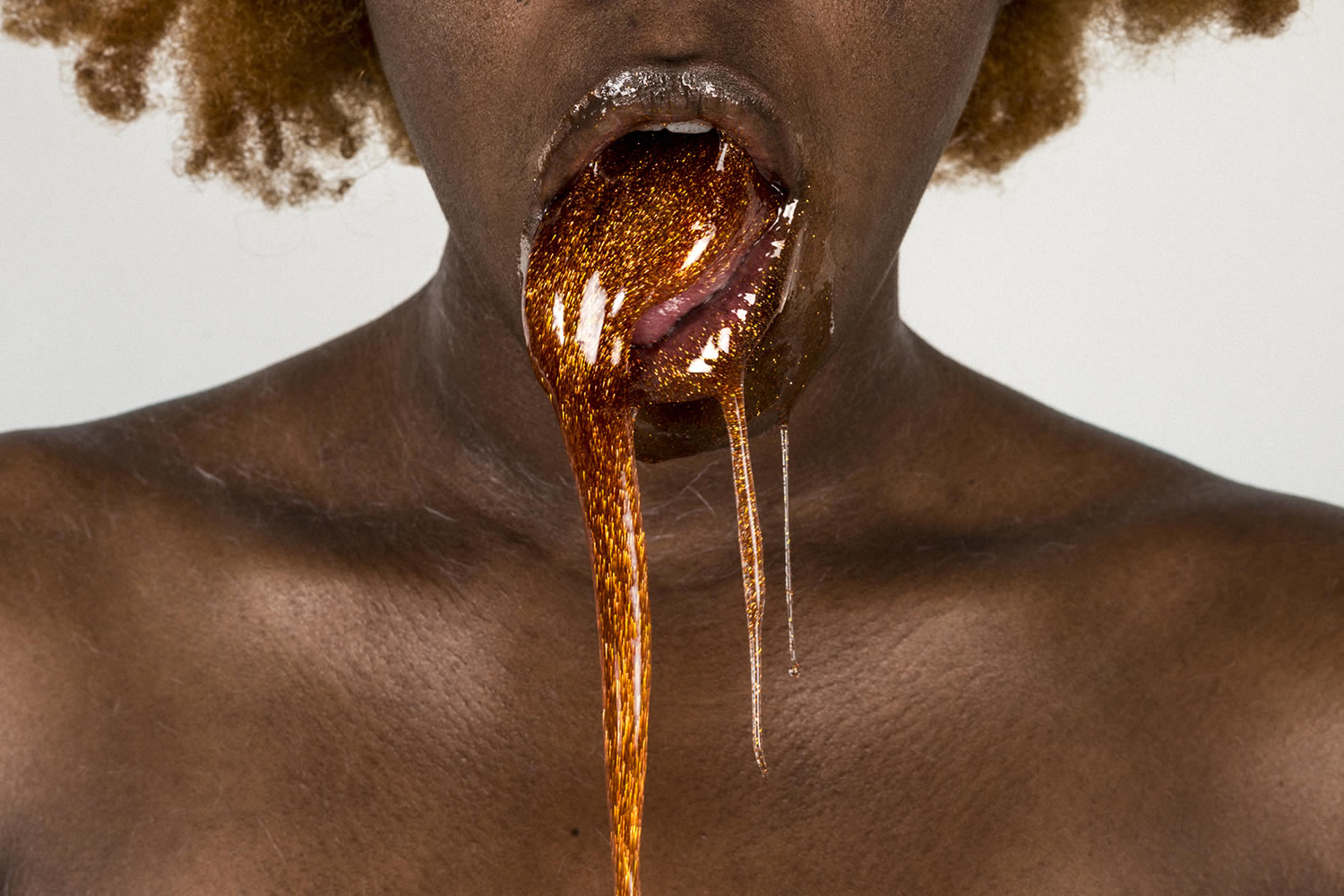honey glitter spilling from woman's mouth