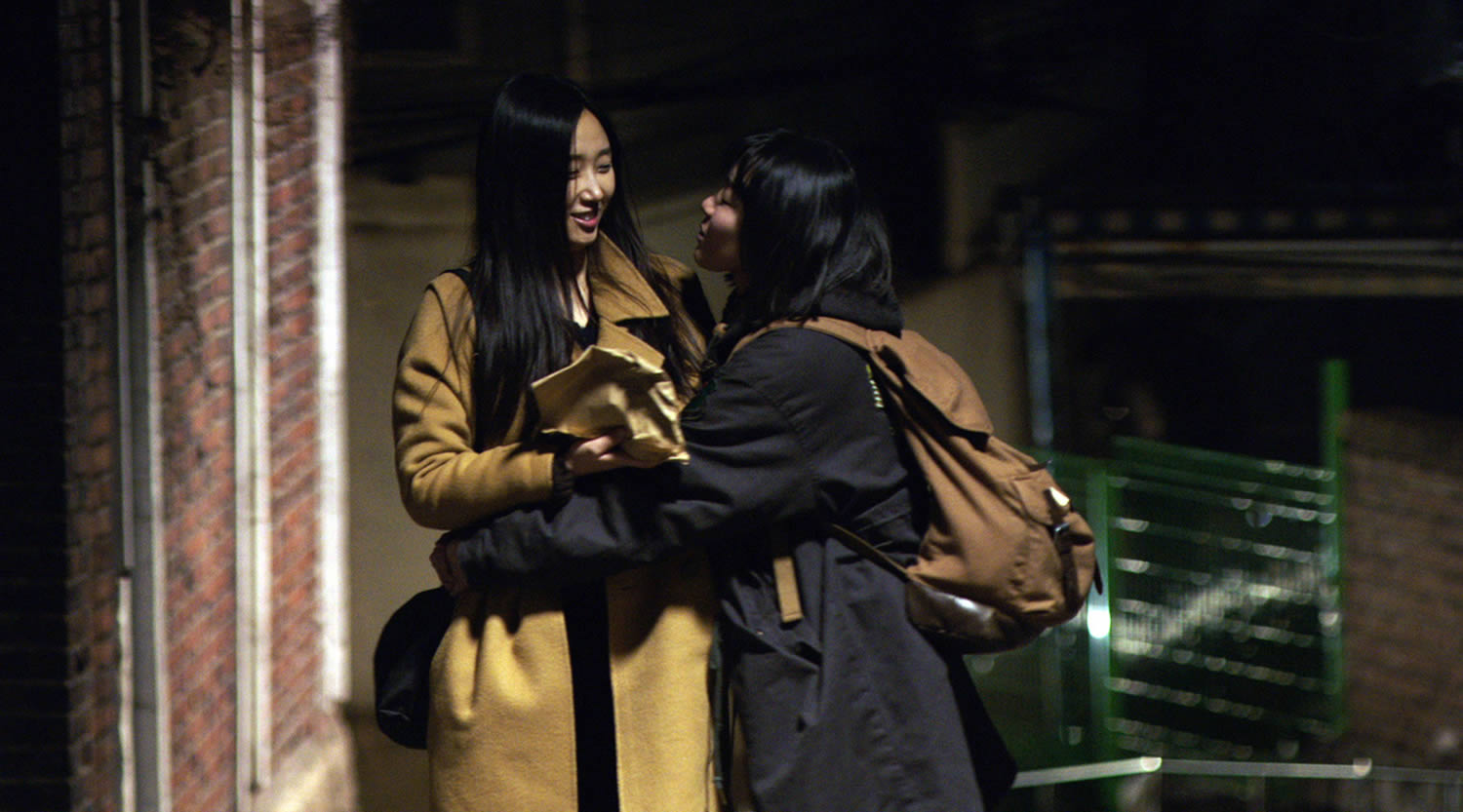 two young women holding hands in a dark alley, our love story (2016)