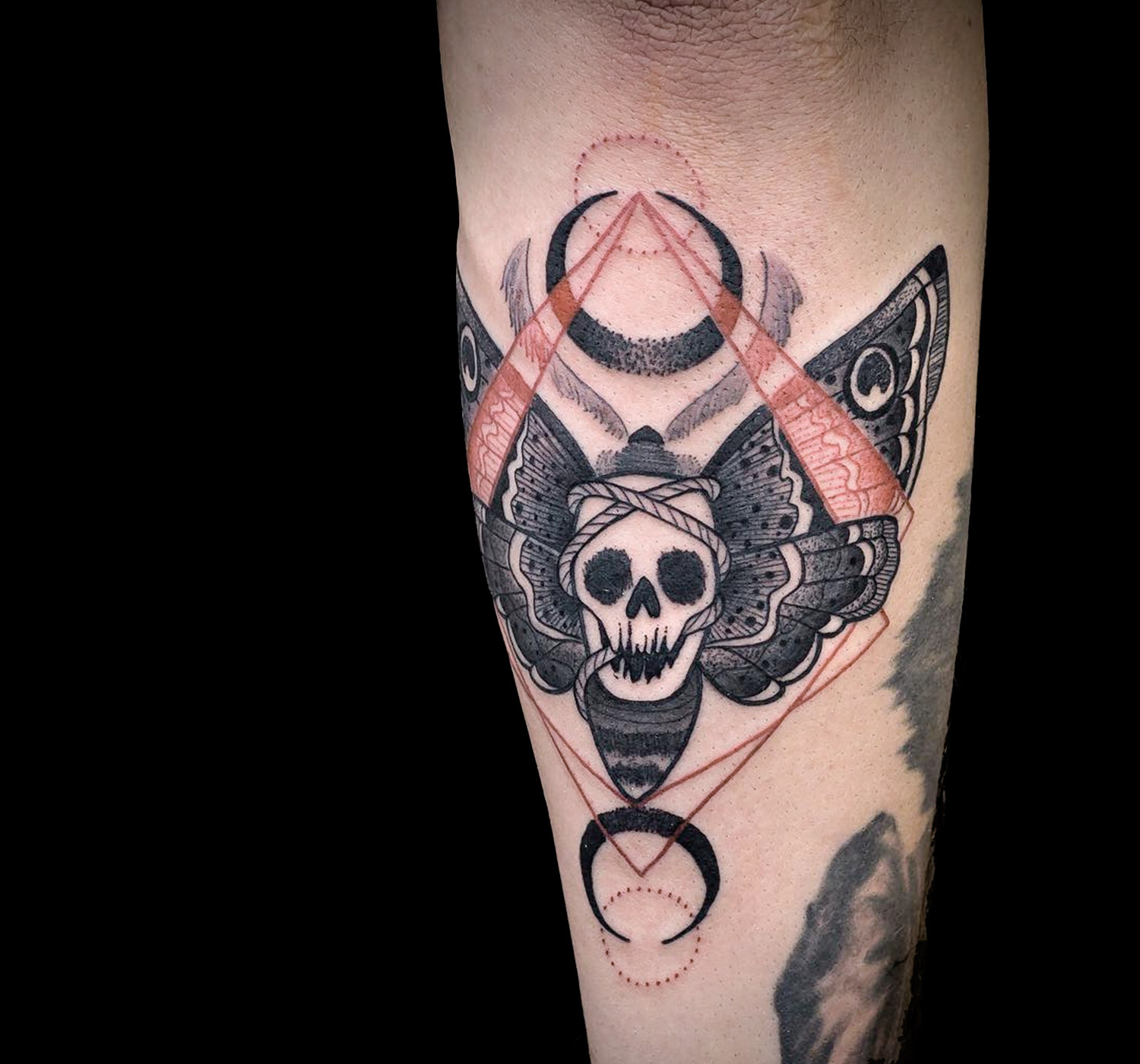 Rød og sort dødsmøl-tatovering af Chris Rigoni