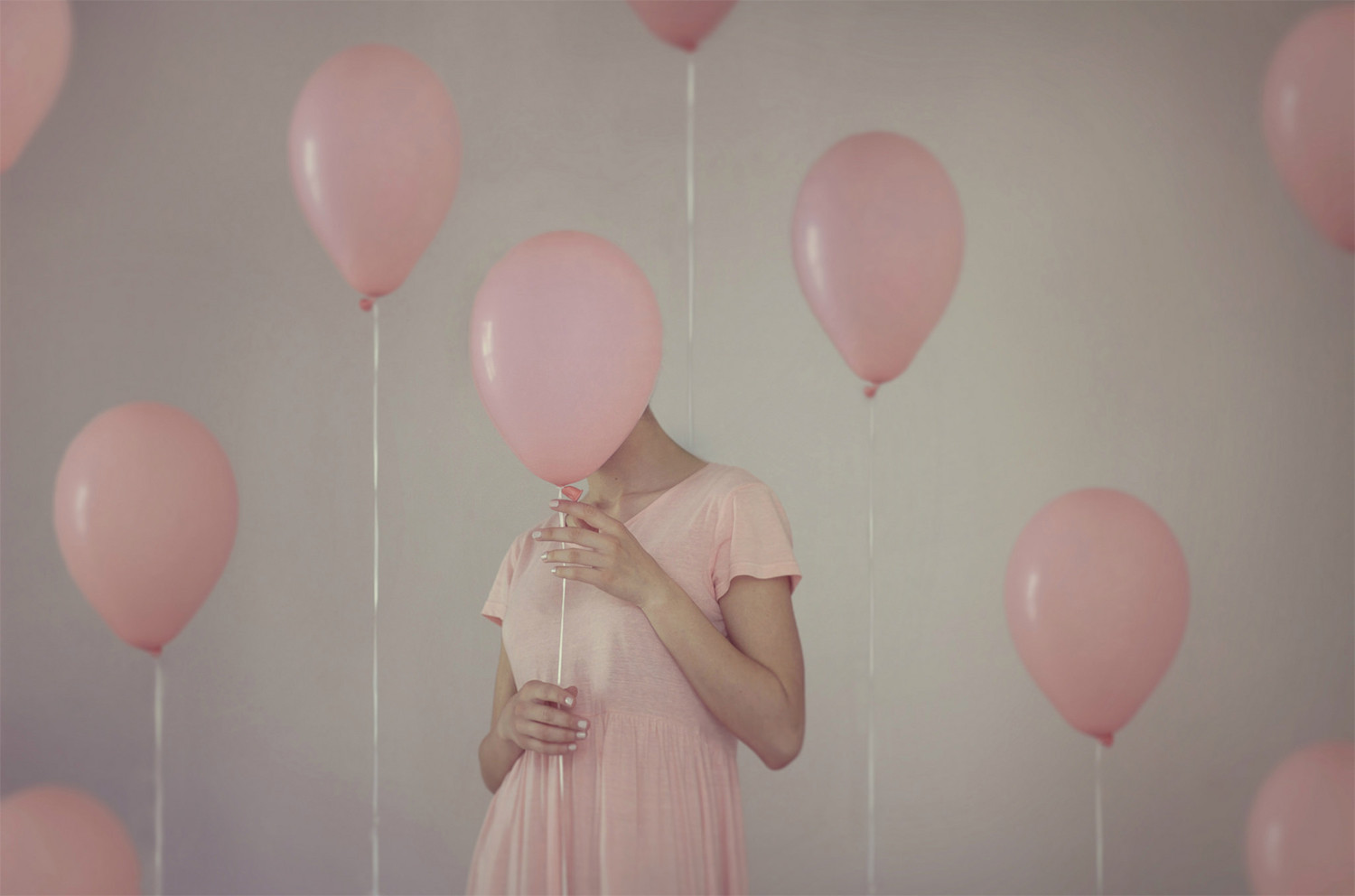 woman hidden in pink balloons