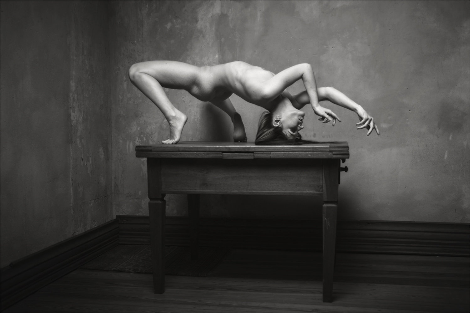 woman doing acrobatics on wood table, photo by René Benjowski Lichtbildgestalten
