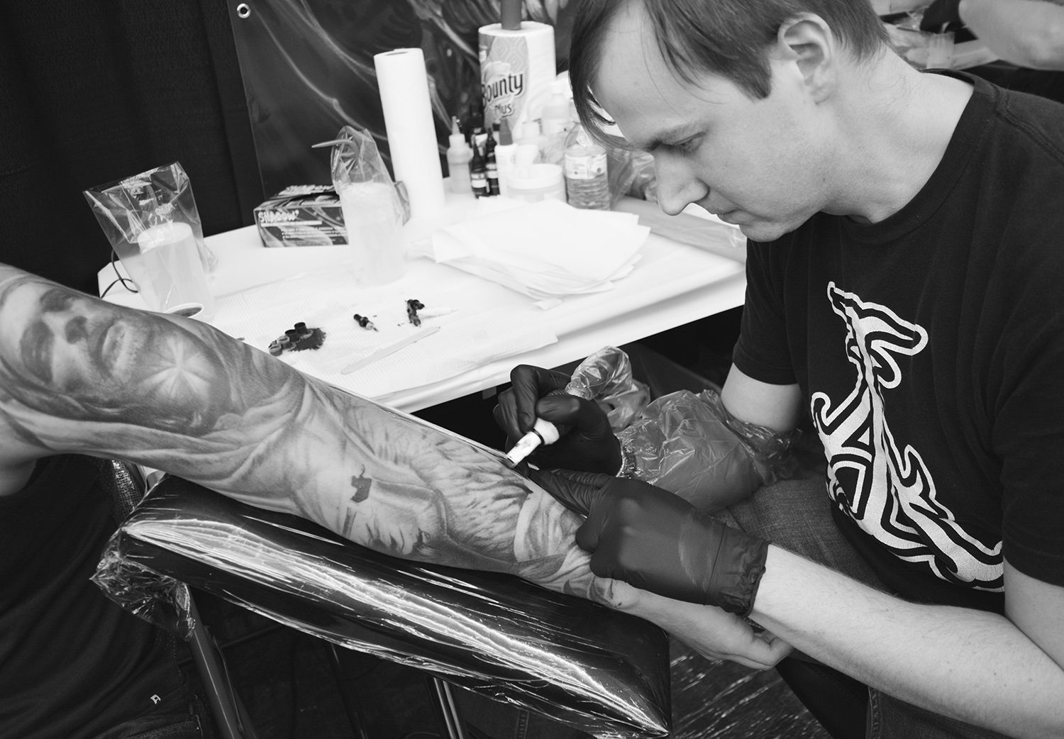 David Gluck tattooing a sleeve at the van isle expo, canada