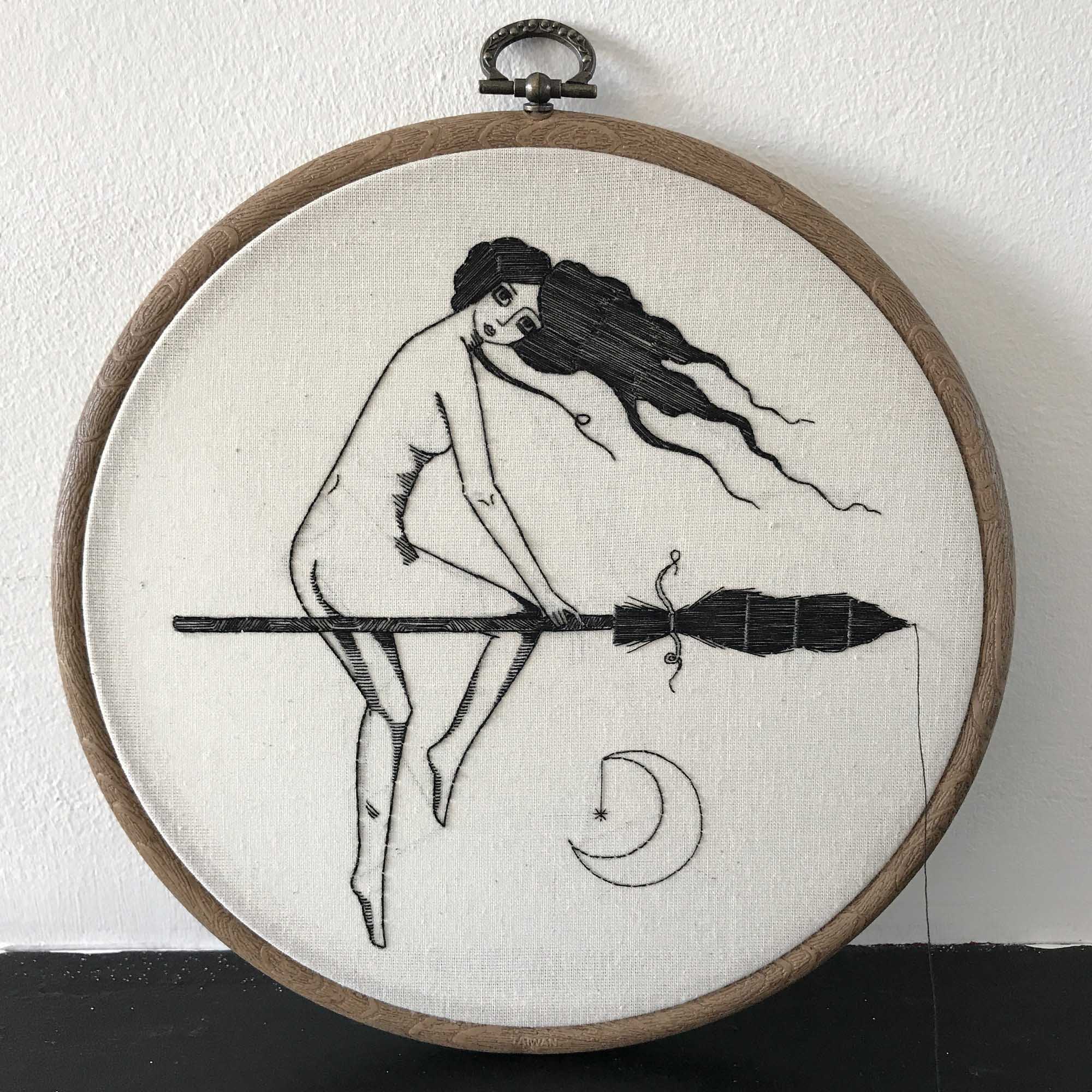 Embroidery of a woman riding on a broomstick