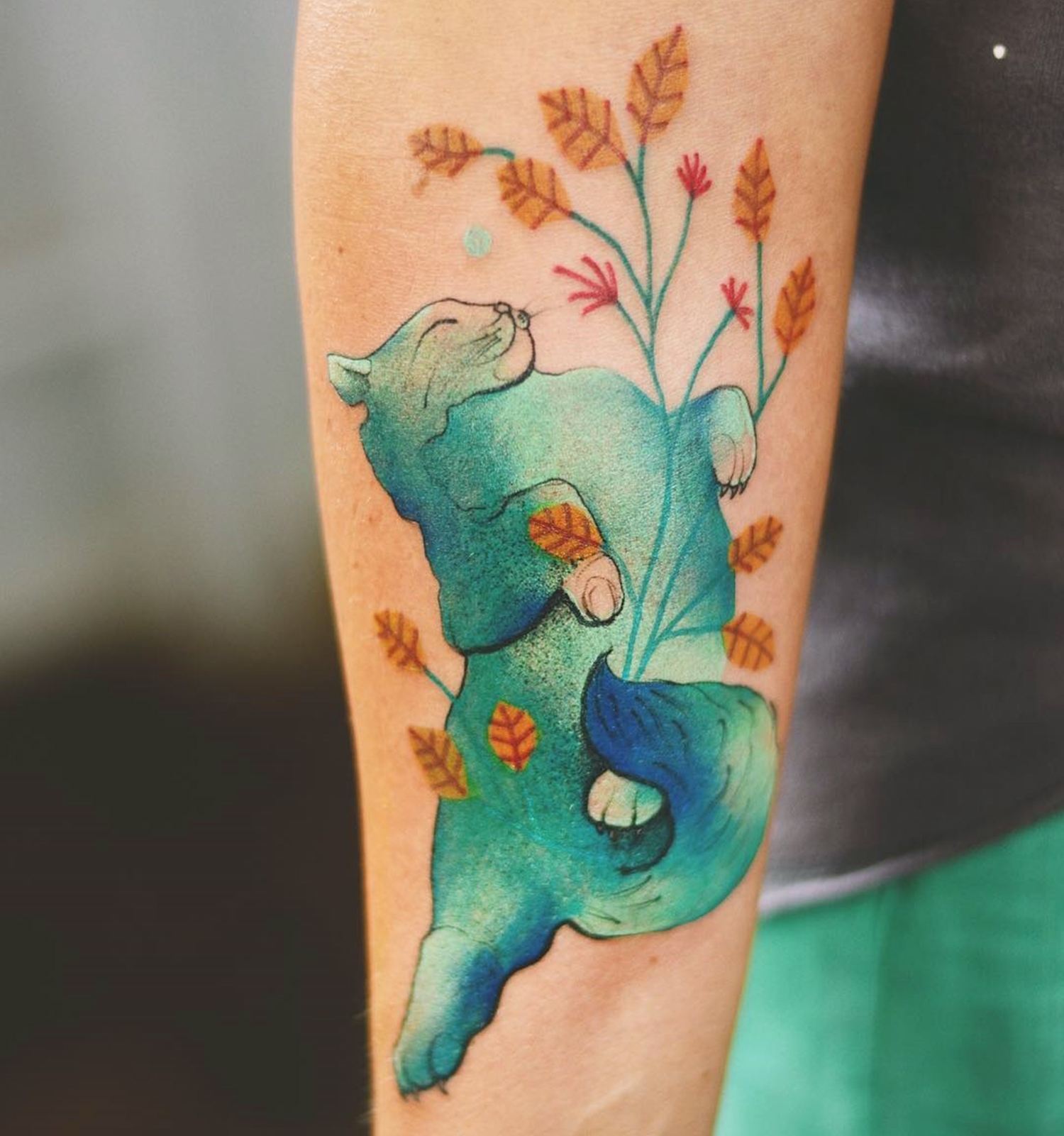 green cat tattoo and flowers