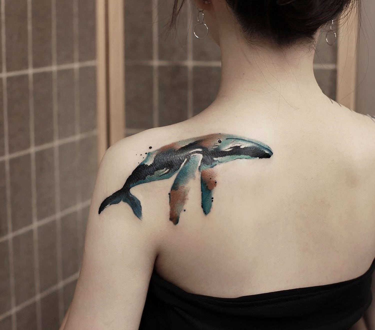 watercolor style whale tattoo on shoulder