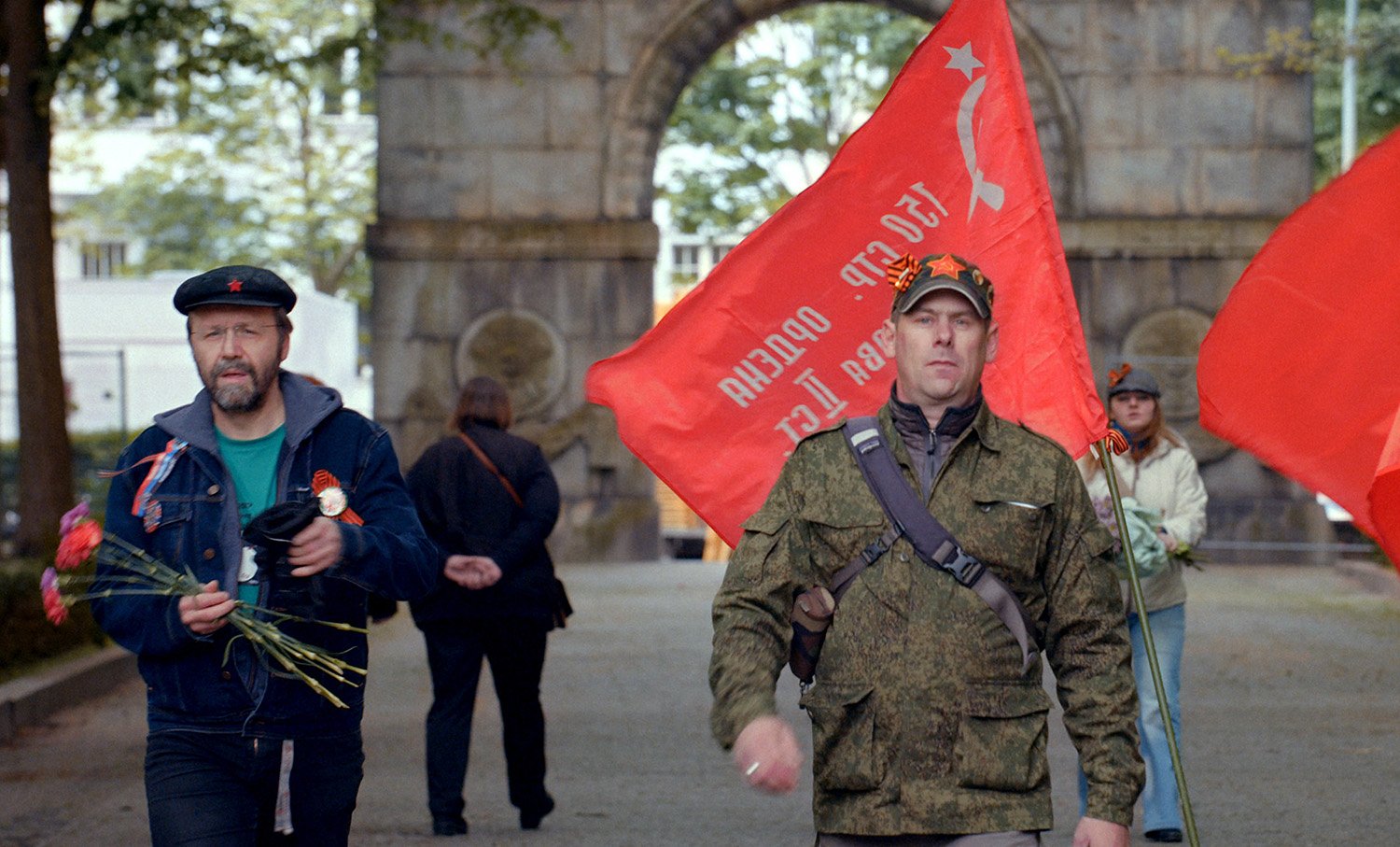 red flags in background, army style guy, victory day movie