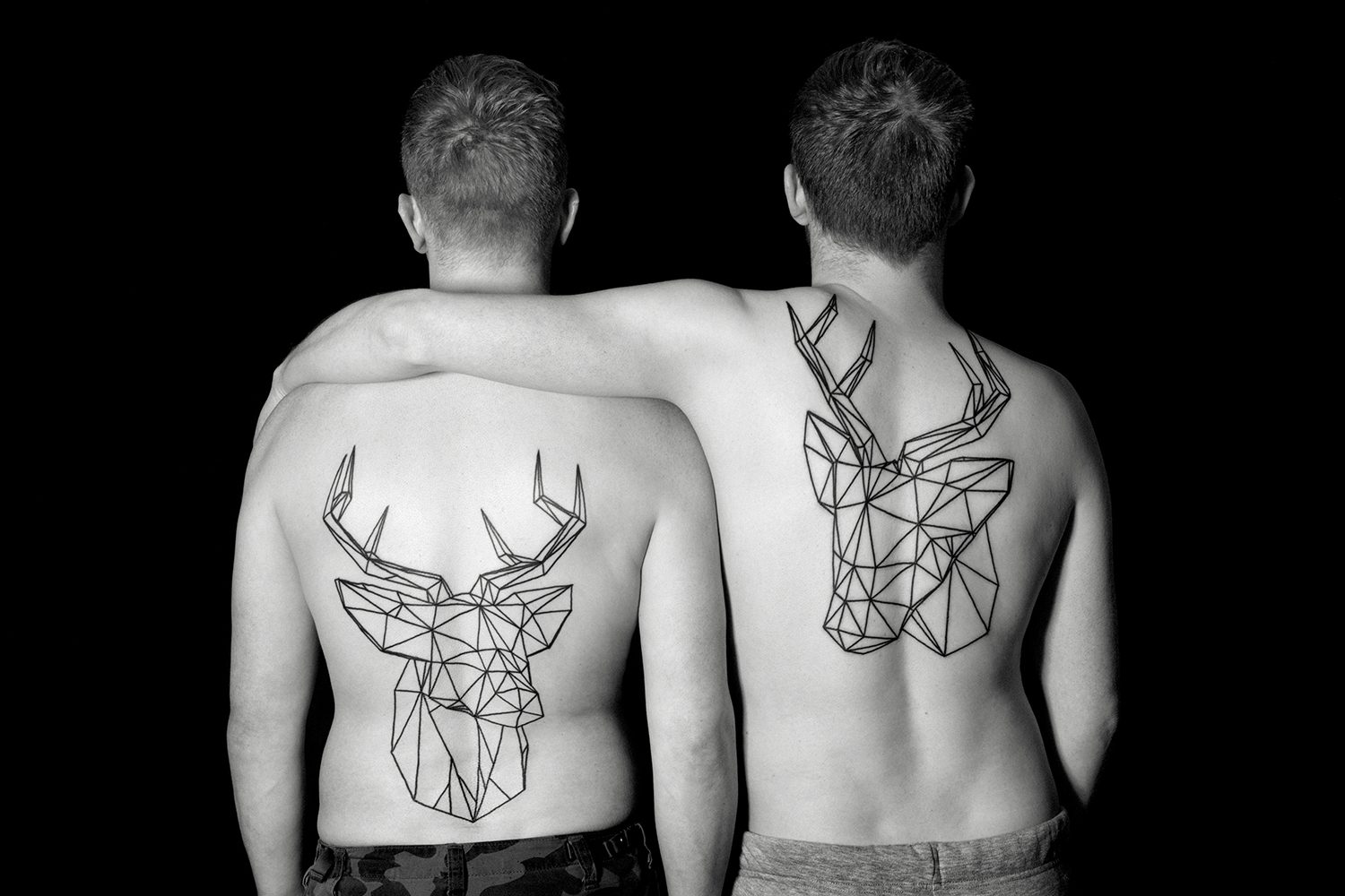 stag tattoos on back, two men. photo © erik weiss